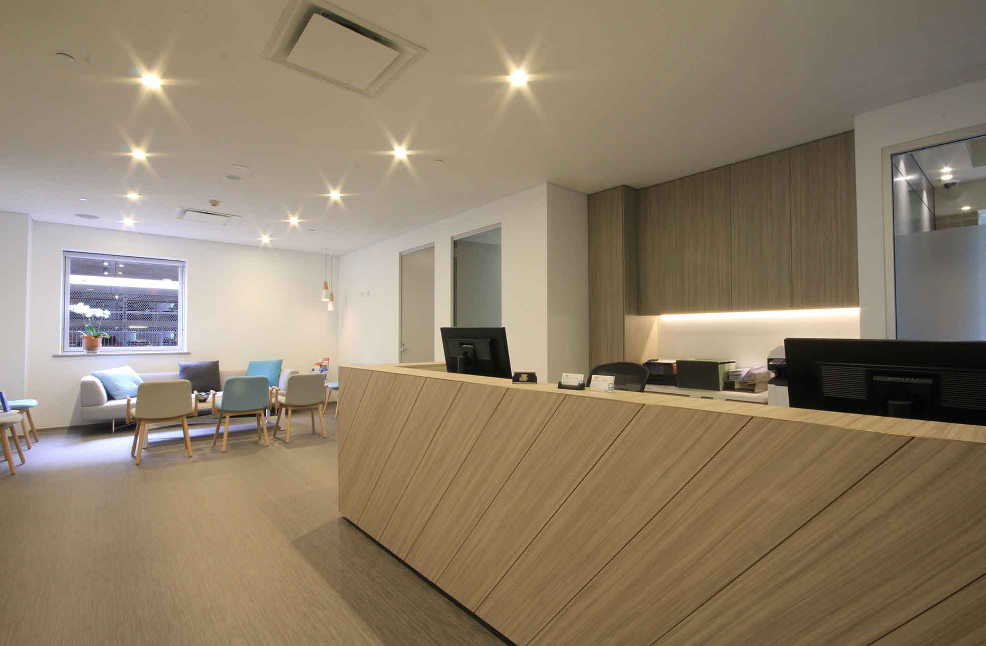 Medical centre fitout, wood-like reception, waiting area with lounge & chairs 