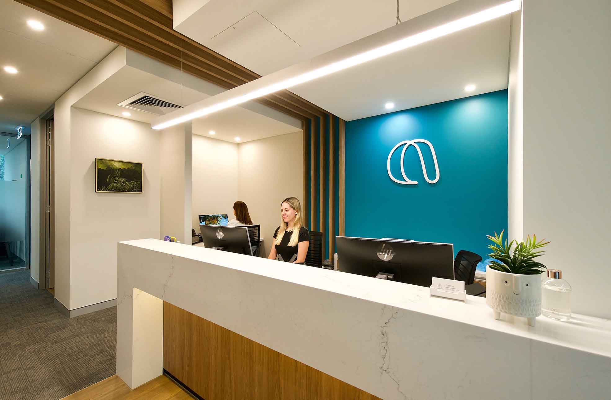 Receptionists behind reception desk in new healthcare fitout 