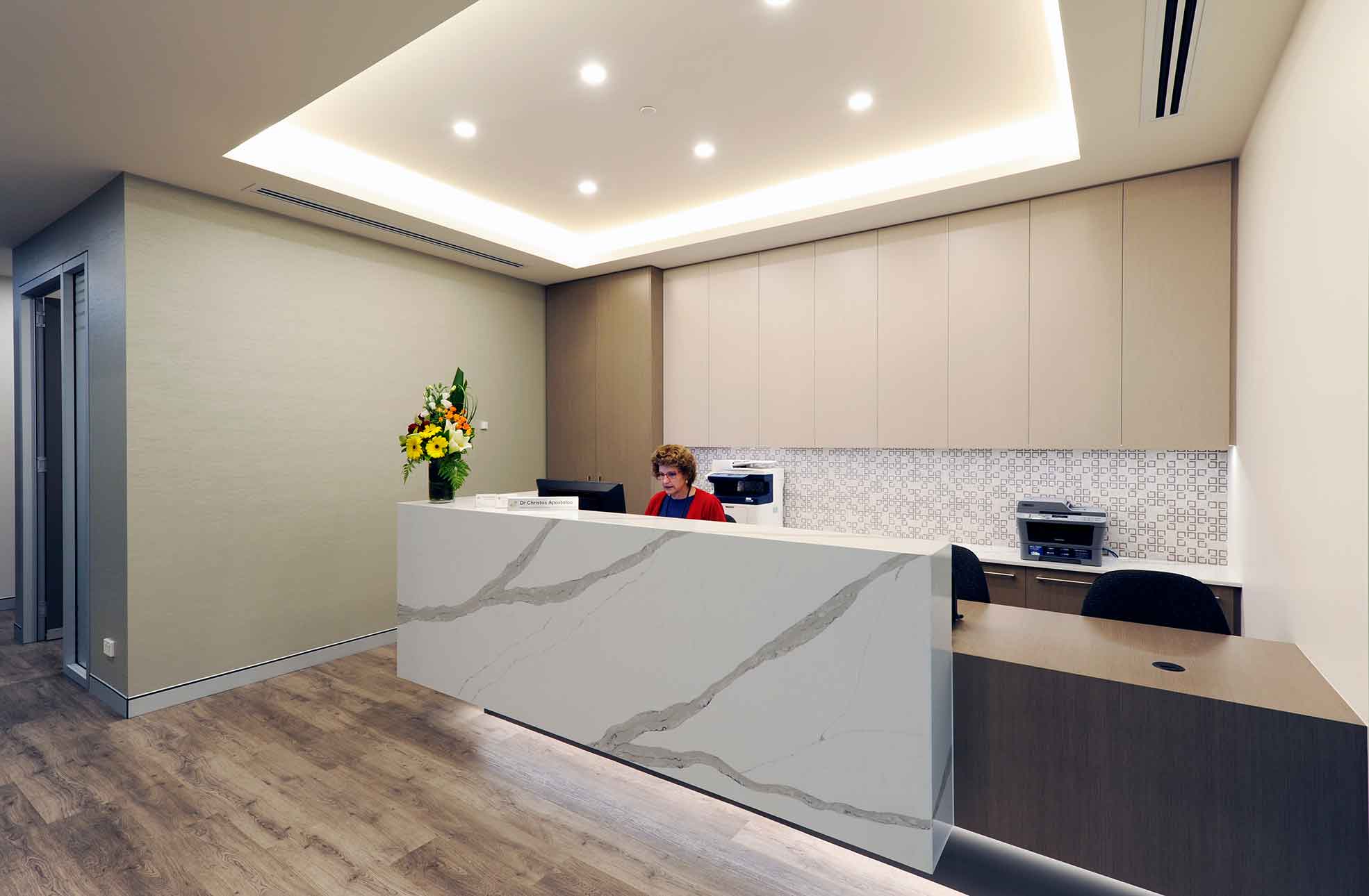 Medical clinic fitout, lady sitting behind reception desk.